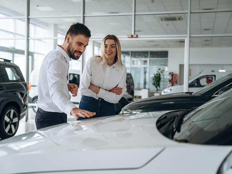 Male SalesPerson Showing Car to Female Customer
