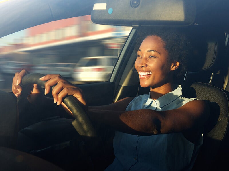 Smiling Woman drivig a Chevrolet Vehicle
